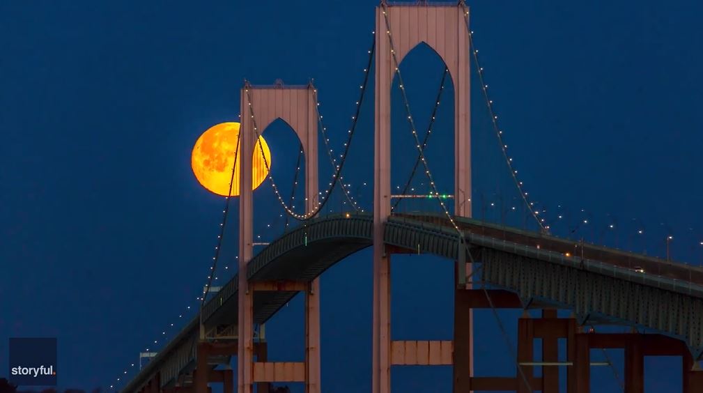 Snow Moon changes from orange to pink as it sets behind Rhode Island’s Newport Bridge
